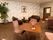 絨毯敷きの部屋に応接セットが複数配置されている。内装全体がモダンな雰囲気である。インテリアとして観葉植物と絵画が置かれている。