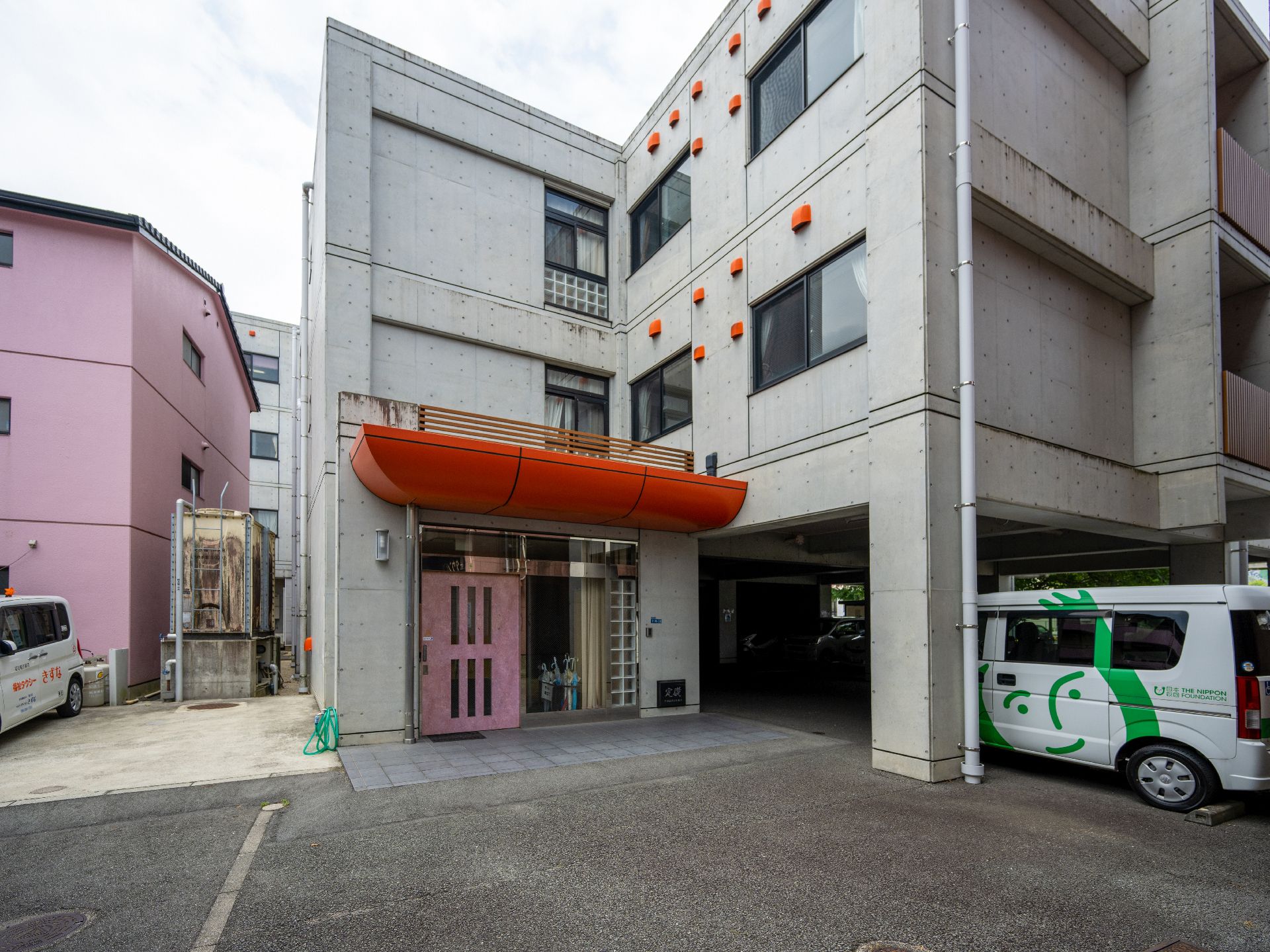 住宅街に立地する３階建てのコンクリートの建物