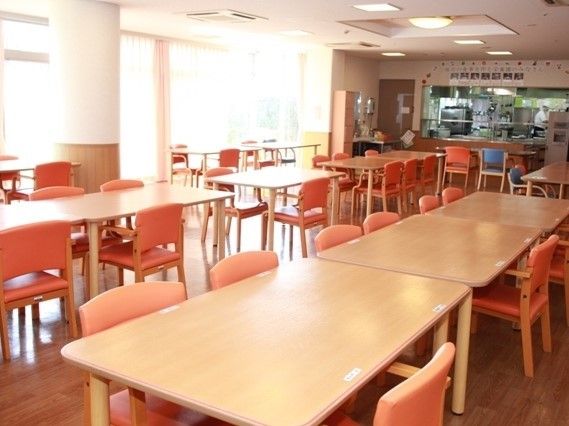 食堂にはシンプルなテーブルが複数置かれている。奥には厨房がある。