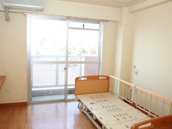 居室のベッドには手すりが付き、窓のそばにはエアコンが付けられている。