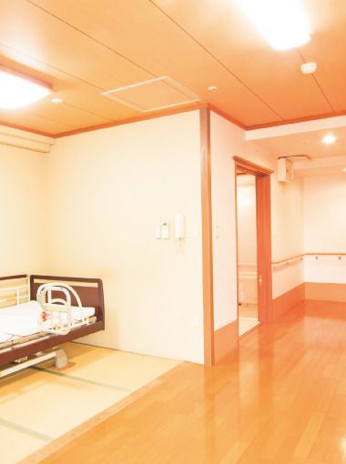 なにかを指さして笑顔で話している車いすの女性とそれを押している介護スタッフの様子