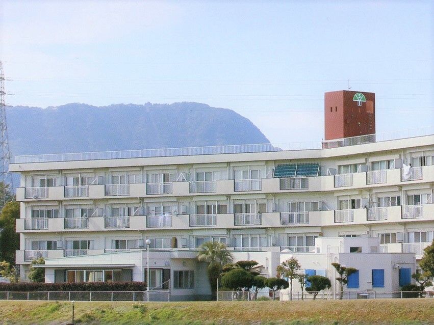 白を基調とした4階建ての建物は周辺を自然に囲まれ明るい雰囲気。各フロアにベランダがあり、玄関には車寄せが付いている。