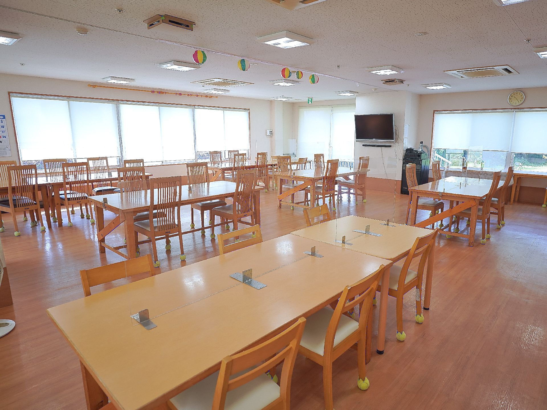 窓から光が差し込み、テーブル、椅子が置かれている共有スペース