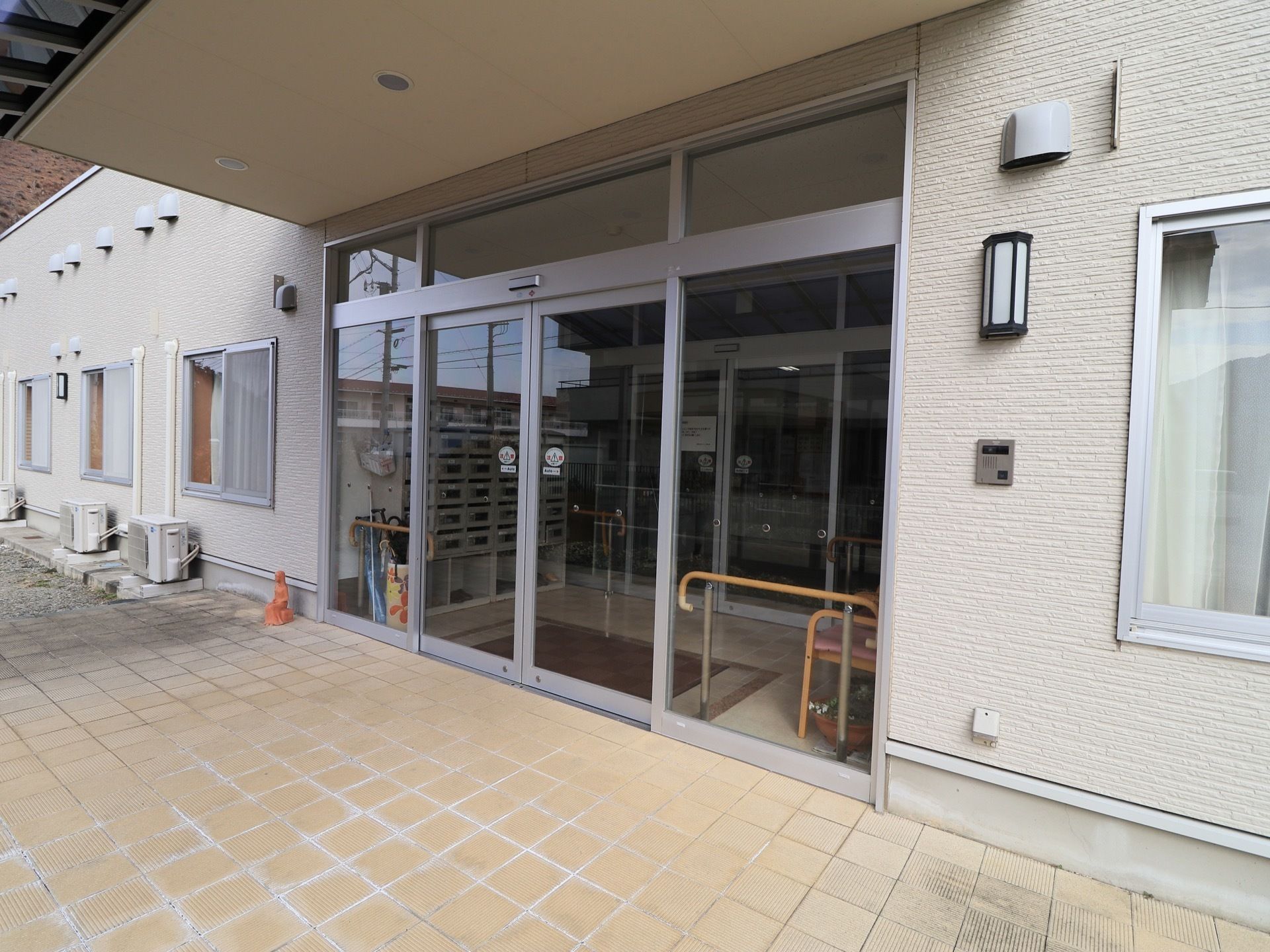 玄関は二重構造になっていて、大きなガラスの自動扉になっている。玄関前には、幅が広く奥行きのあるひさしがある。