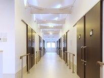 手すりが両サイドについた廊下。突き当りには窓つきのドアがあり、日当たりも良好。