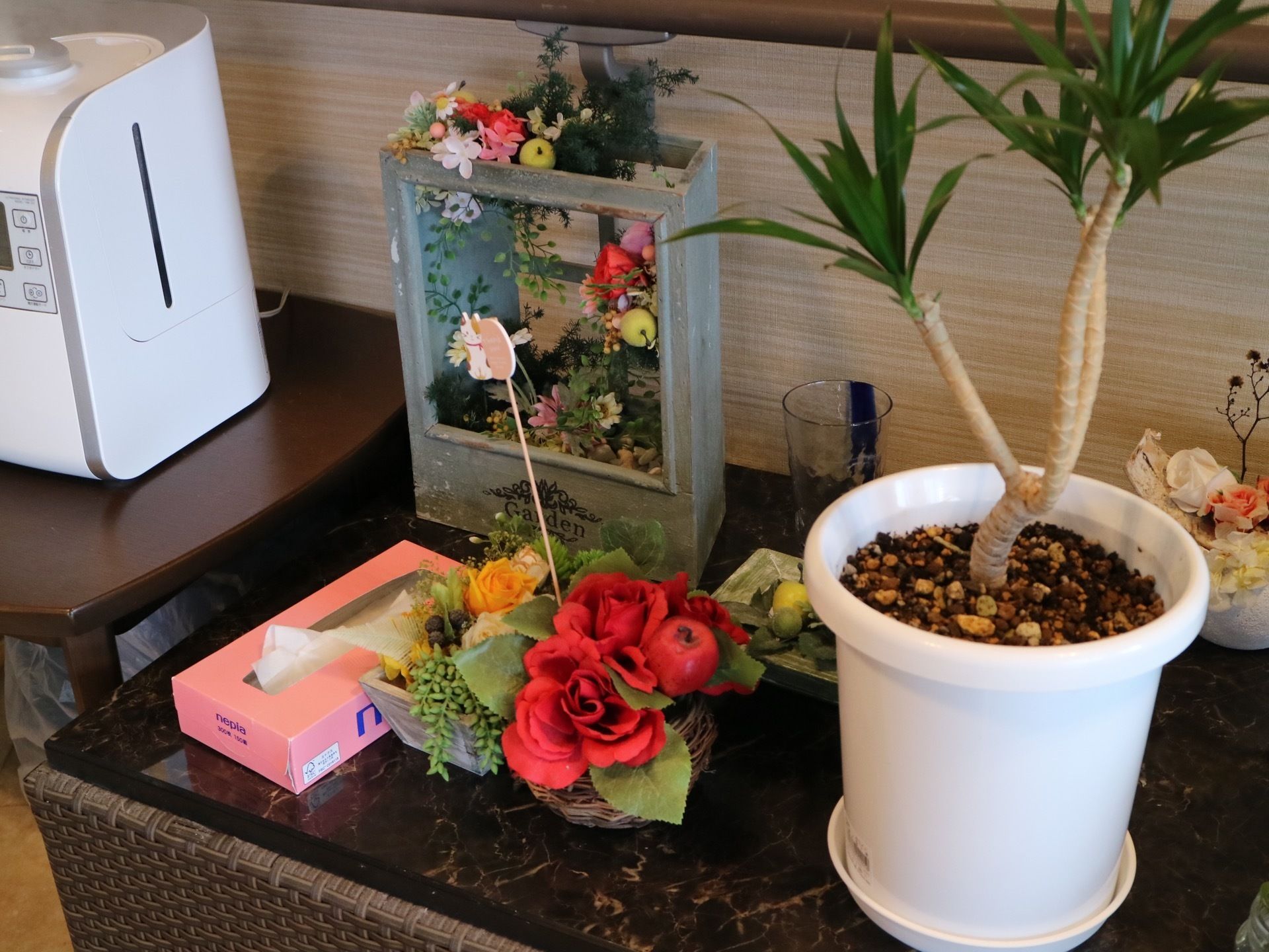 ラウンジのローテーブルには、観葉植物やプリザーブドフラワーなどが飾られている。色とりどりのアレンジメントが華やかさを添えている。