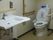 木製の手すりが両サイドに設置されたトイレは広く、手洗い場も付いている。
