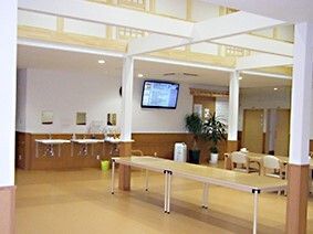 木製の長テーブルがたくさん置かれたホール。壁際には車いす対応の洗面所がある。