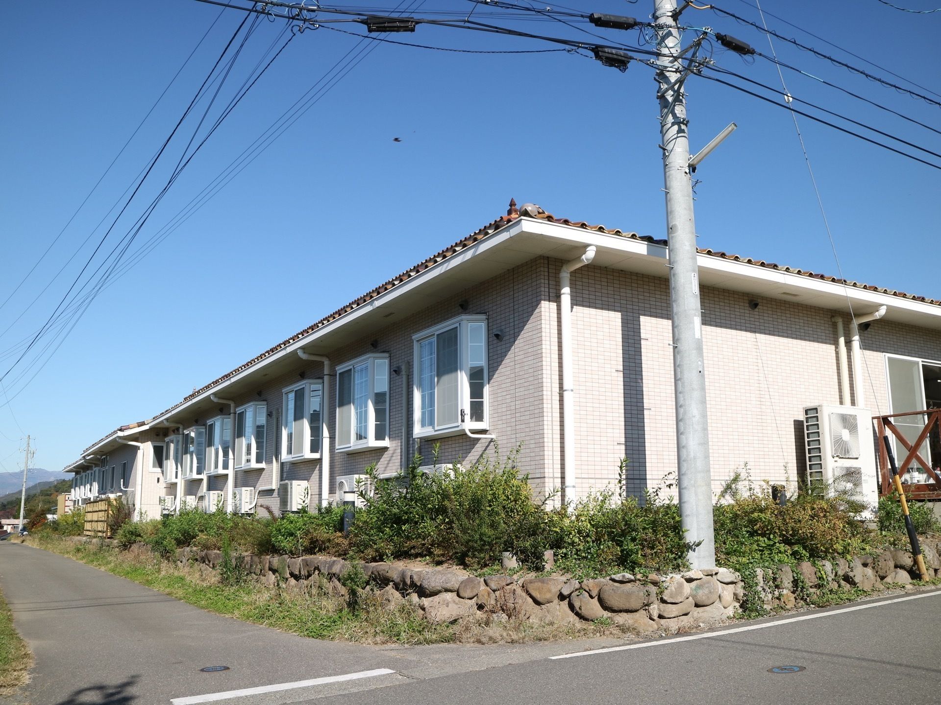 広い敷地にタイル張りのおしゃれな建物が、平屋建てで建てられている。周囲は防犯のため、石垣と木で囲まれている。