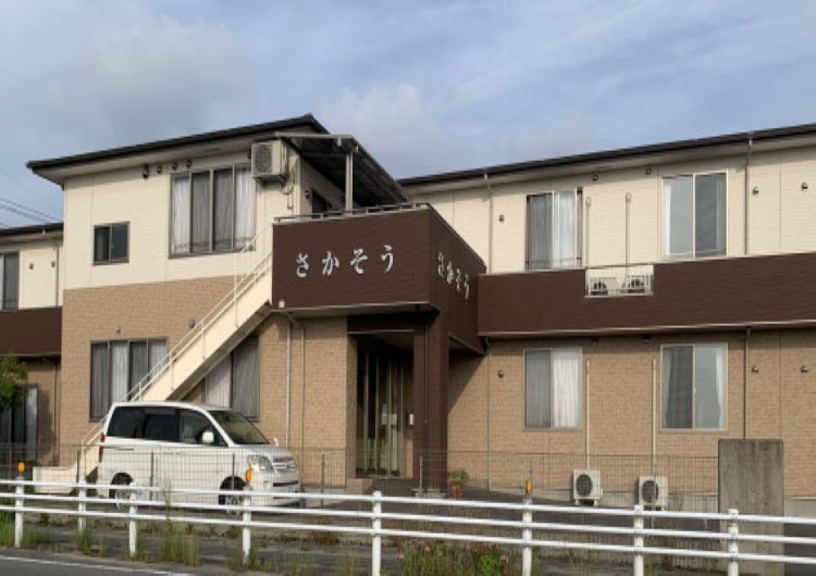 ベージュのソファを囲んでおしゃべりをしている高齢女性たちと白衣を着た女性スタッフ。