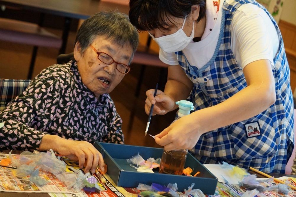 手芸活動をする高齢者とスタッフ