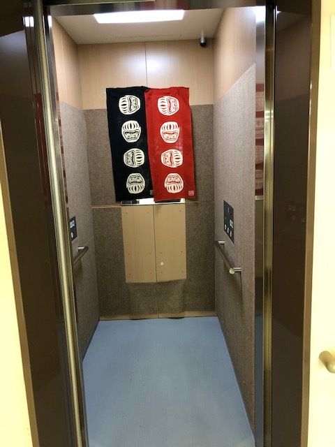 エレベーターの中には黒と赤の布が飾られ、手すりも設置され、安全に利用できる。