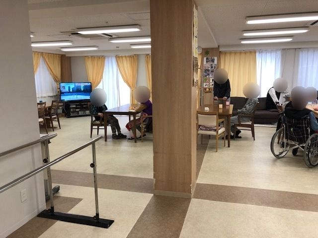 廊下には平行棒が設置され、食堂にはソファやテーブルが複数置かれ、思い思いの場所で入居者が過ごしている。