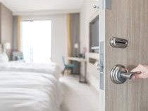 個室のドアを開けて中をのぞいている様子。ベッドや調度品が置いてある