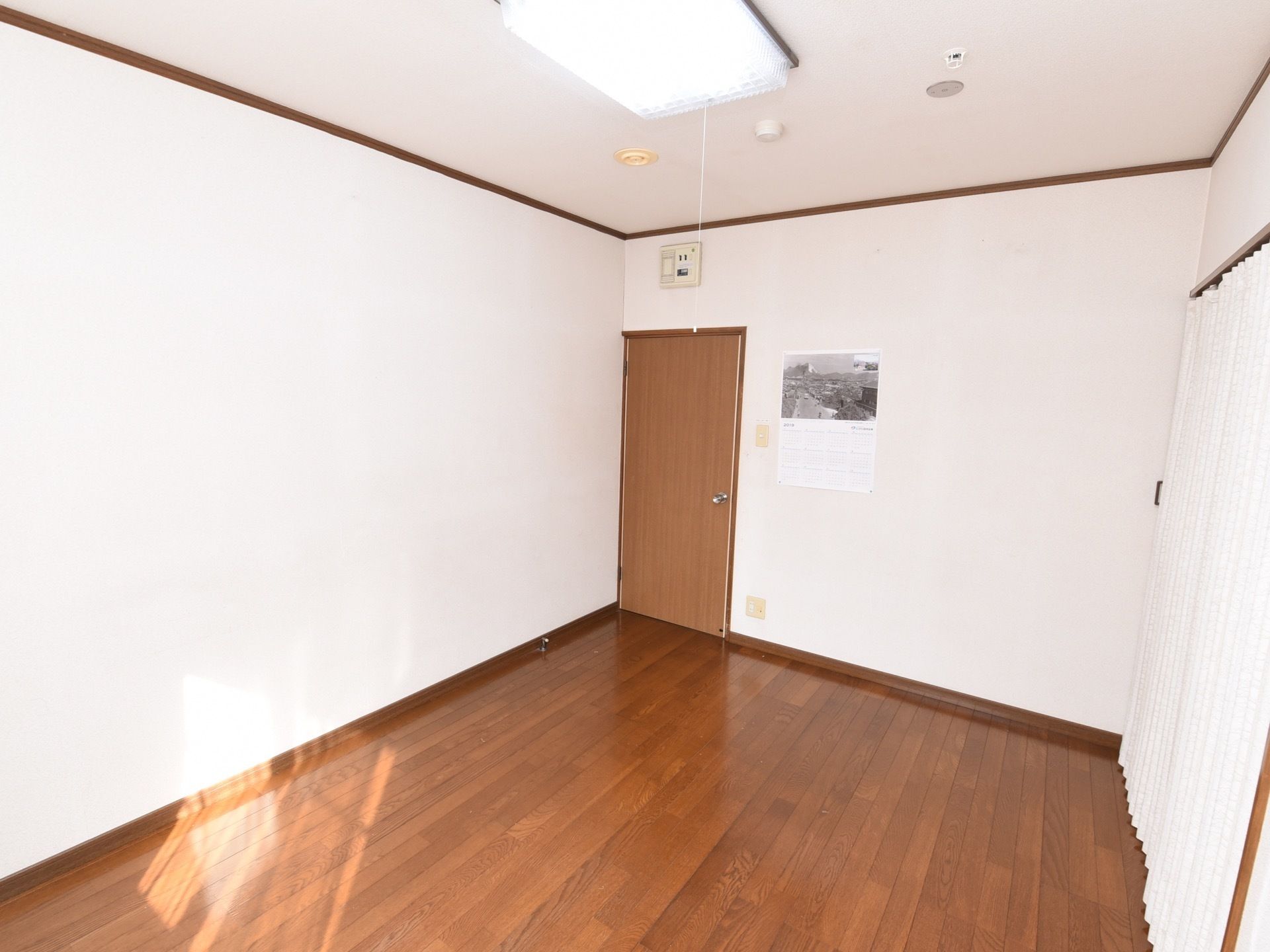 居室の天井には、中央に四角いシーリングライトが設置され、非常用の火災探知機やスプリンクラーも備えつけられている。