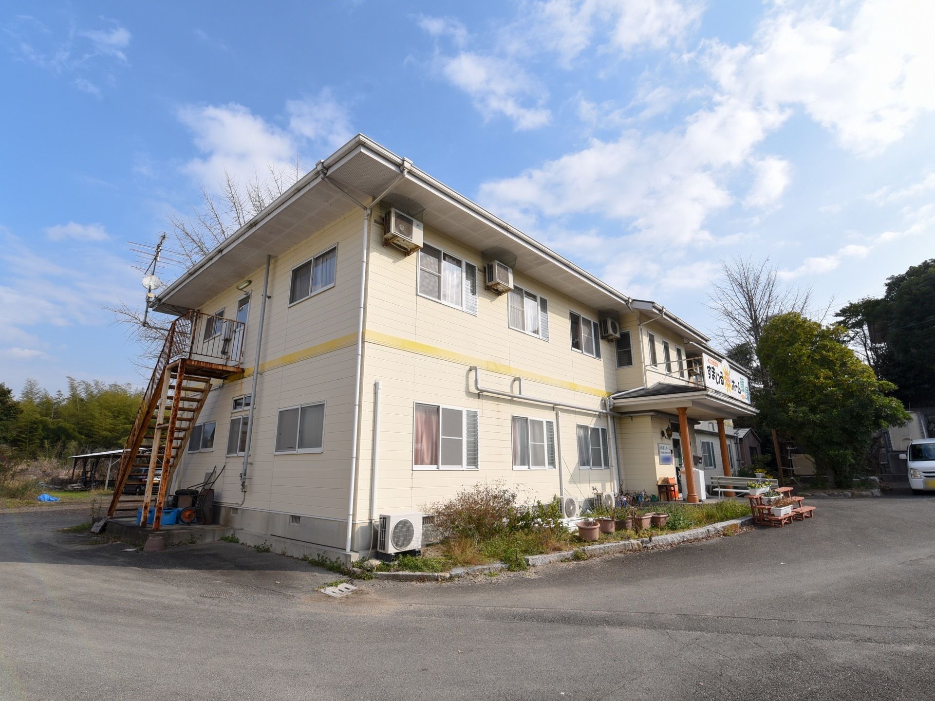 施設は、広々とした敷地に建ち緑豊かな自然の風景に囲まれている。建物は２階建てで同じ形の窓が多数並び、玄関は三角屋根がついている。