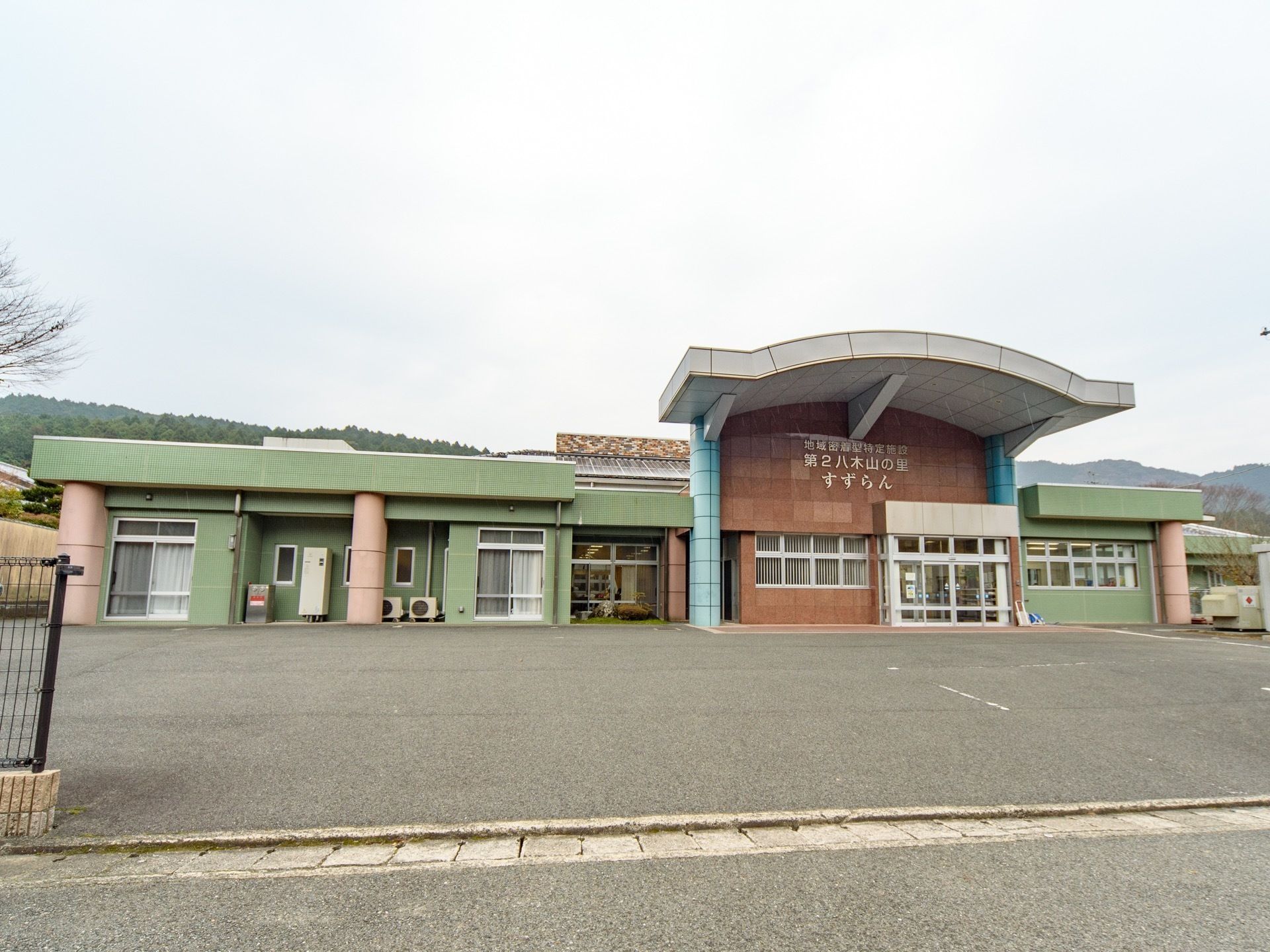 広い面積を有したスタイリッシュな建物。敷地内にアスファルトで舗装された、広い駐車場が完備されている。