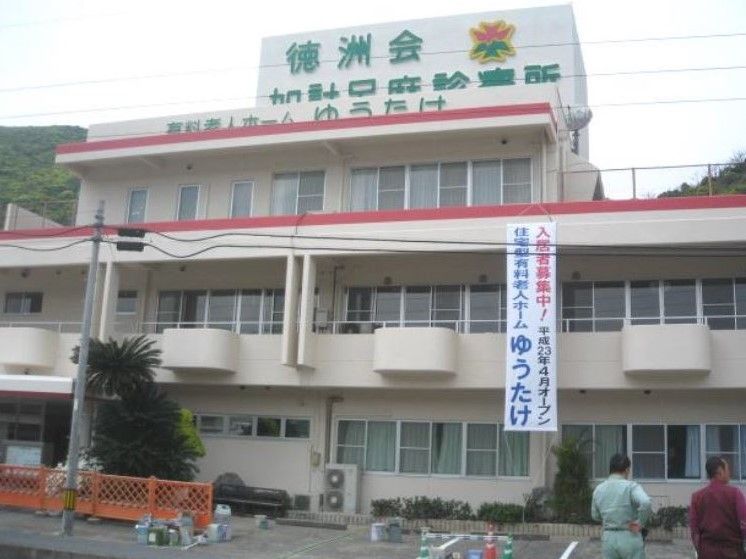 ホームの外観。白を基調とした建物で、２階部分と３階部分に赤いラインが入っている。