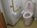 エル字型の手すりやグリーンの呼び出しボタンが設置されているトイレは広い。