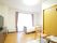 大きなドアが付いたフローリングの部屋にはテレビや寝具がセットされたベッドがあり、大きな窓が付いている。