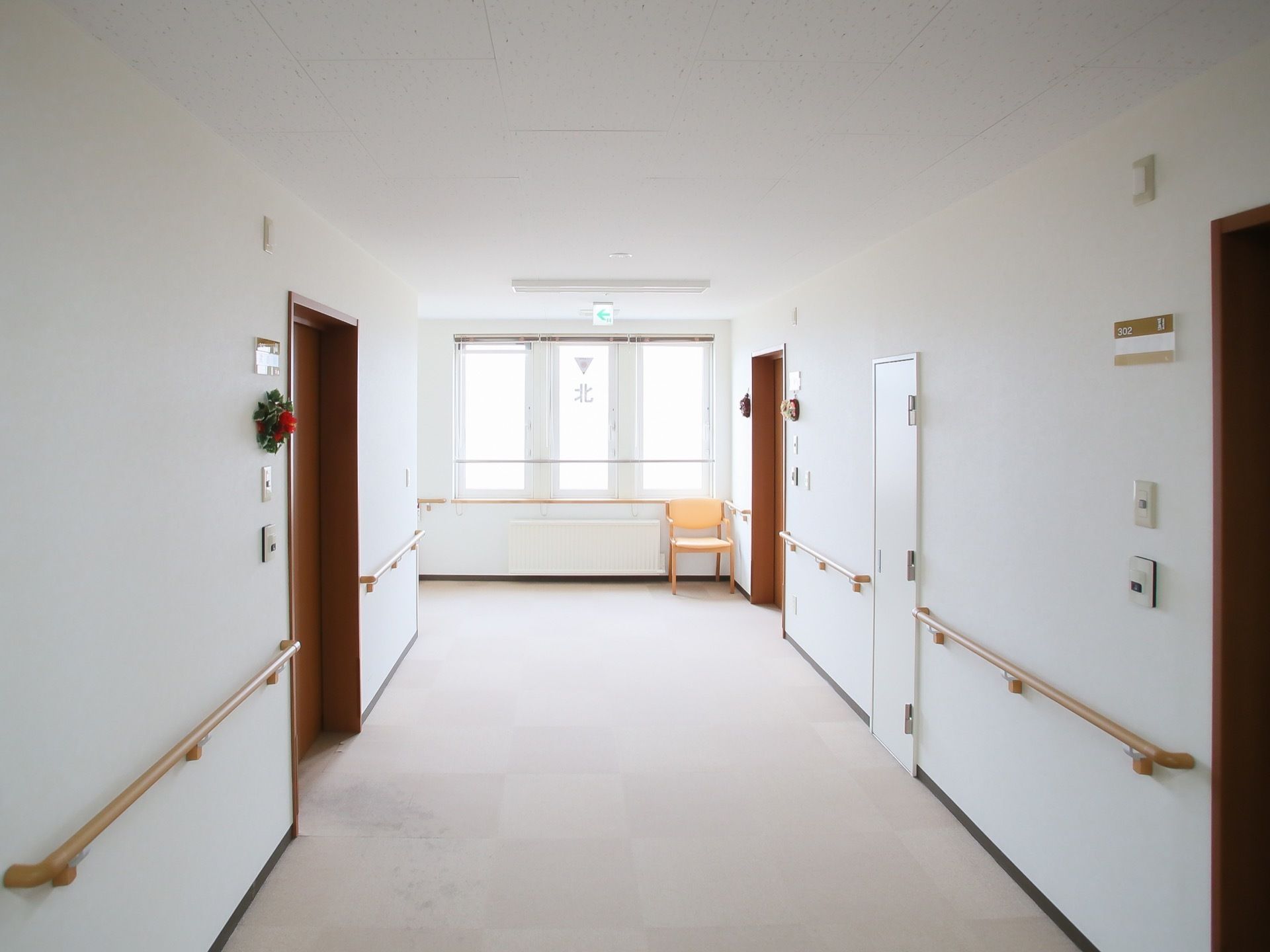 白を基調とした幅の広い廊下である。窓から射し込む自然光が室内をあたたかくし、また明るい印象を与えてくれる。