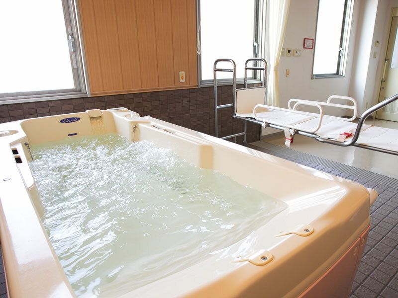 手前にはお湯が張られた浴槽があり、その奥にはストレッチャータイプのリフトが設置されている。