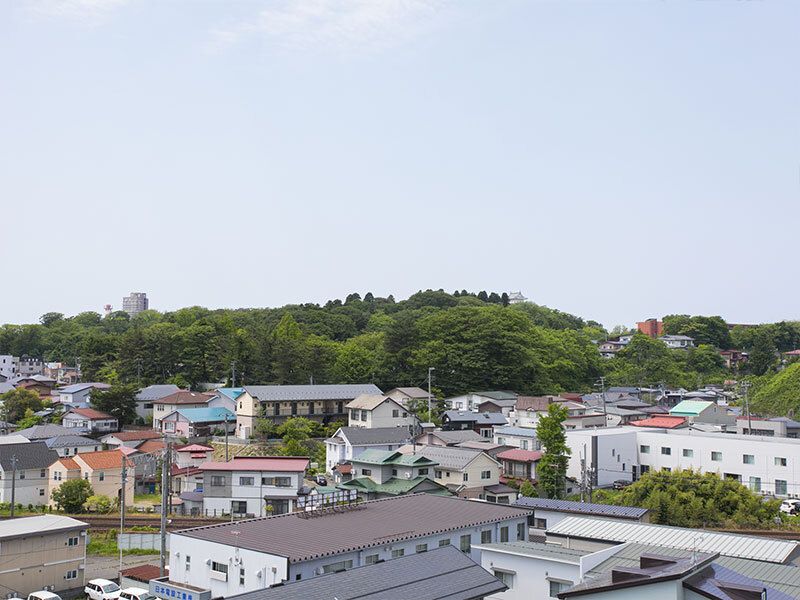 周辺には住宅も多くあり、奥には緑豊かな丘もある。背の高い建物はあまりなく、見晴らしがよい。