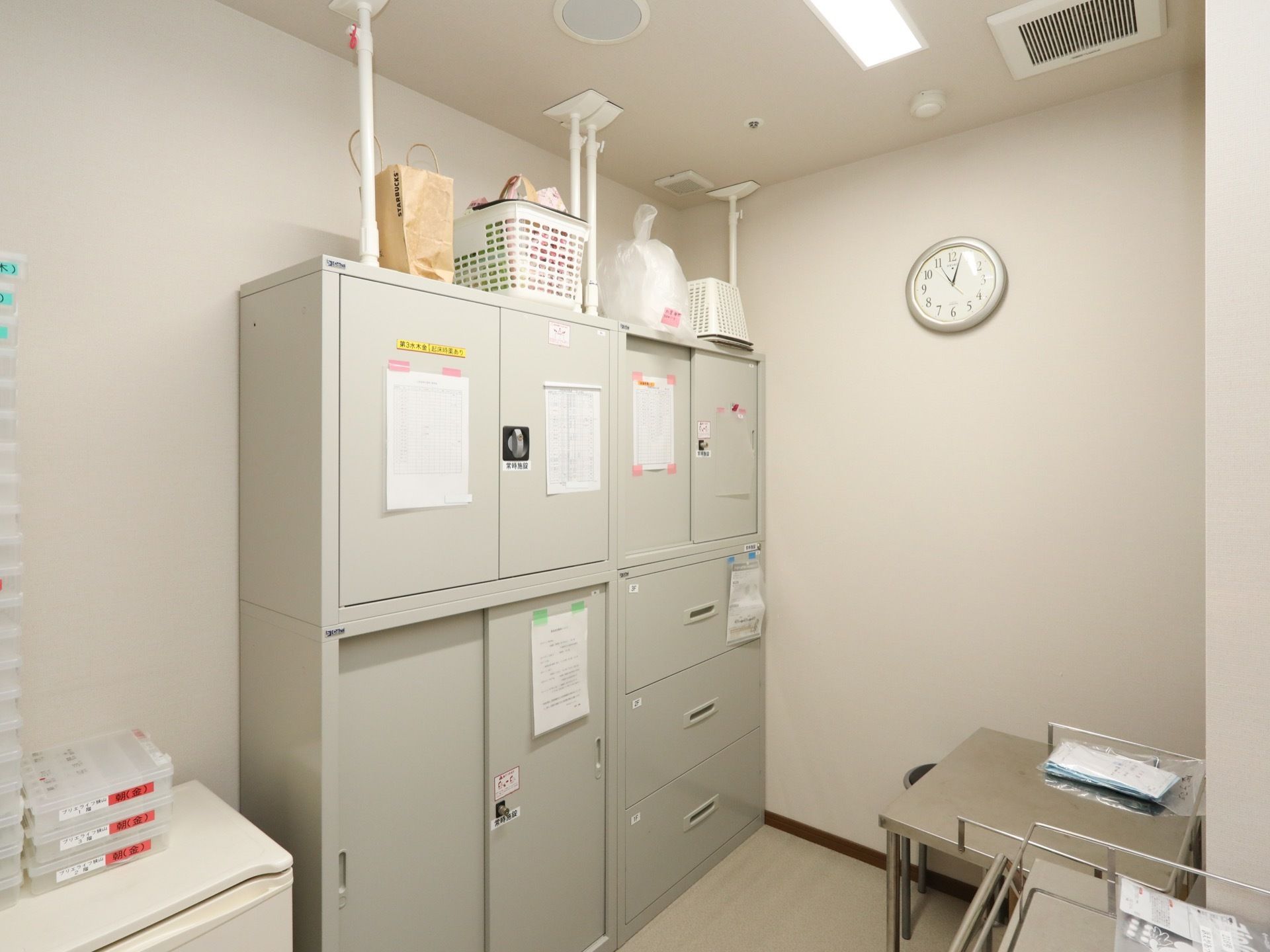 グレーの書類棚が置かれており、耐震対策のストッパーで固定されている。書類棚は扉に鍵がついているスペースと、引き出しのスペースがある。