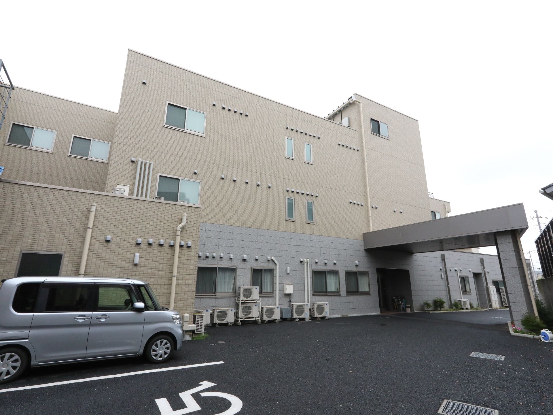 天気が良い日にプリエライフ狭山を写した写真。マンション風の鉄骨造の建物