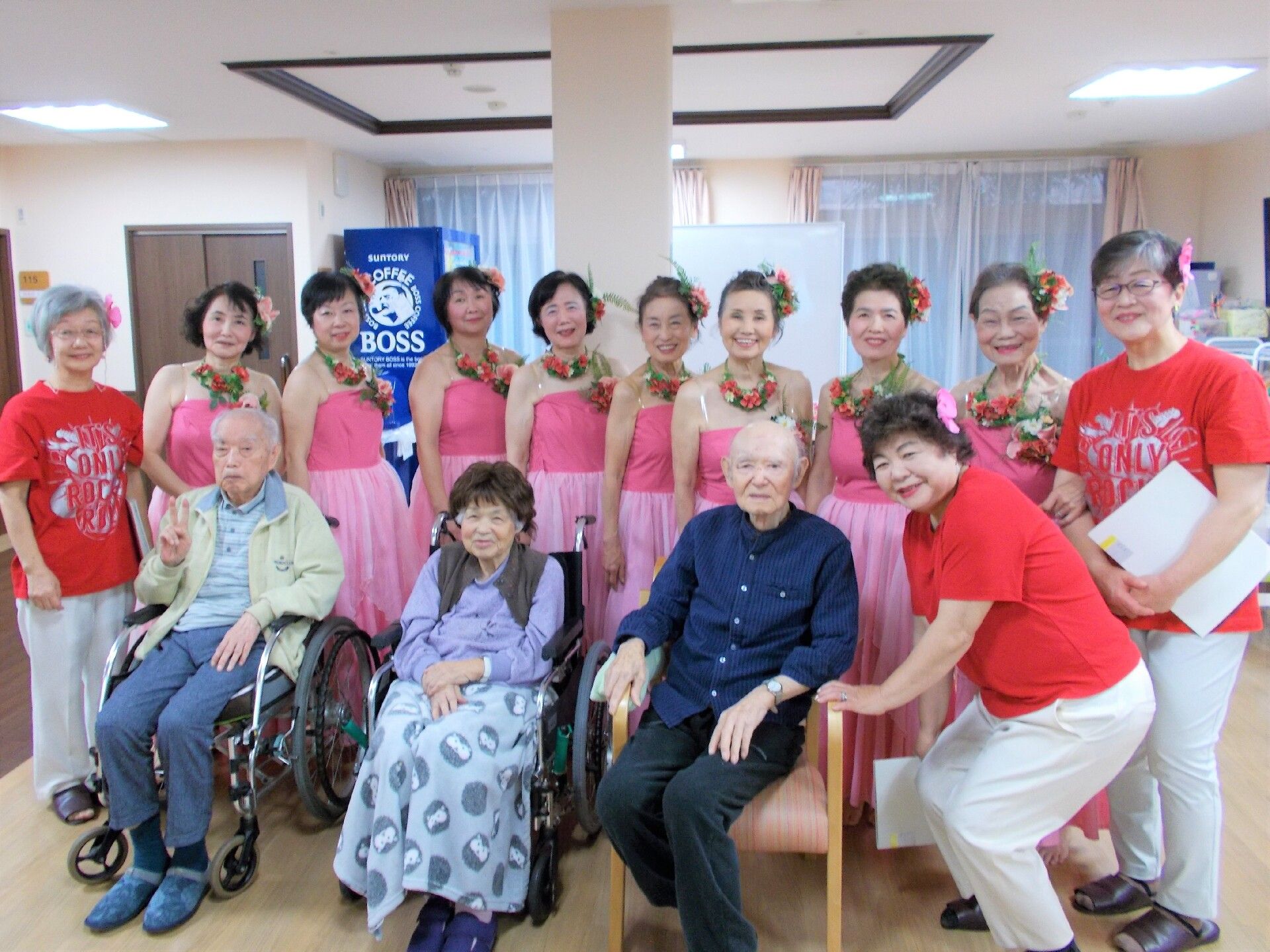 フラガールと一緒に写真におさまる高齢者と施設スタッフの様子