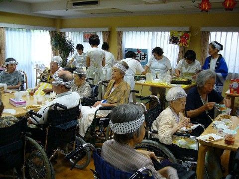 施設内のお祭りイベントの食事時間にダイニングルームに集まって食事をする様子