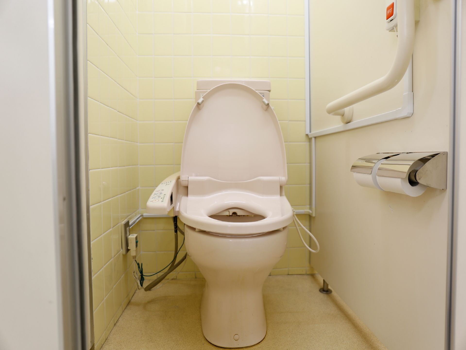 個室内のトイレには、L型手すりが付いている。ナースコールが設置されている。ウォシュレットの付いた洋式便所である。