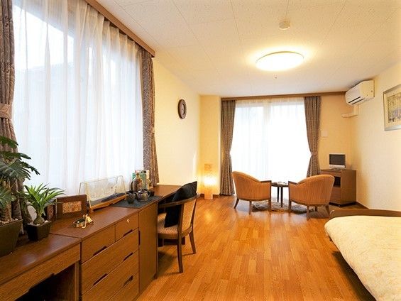 左側にタンスや机、奥のほうにソファがあるワンルームタイプの部屋の様子