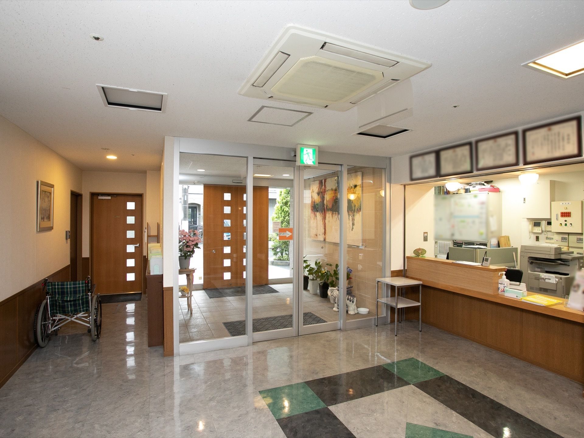 二重ドアで、ドアとドアの間には、花瓶やプランターが置いてある。ドアの前には、玄関マットが敷かれている。
