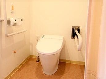 車いすに乗った男性とその人に話しかけている女性。家族で話している様子を写した写真