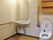 手すり付きのトイレの様子。横にはフットレスの洗面台があるのが分かる