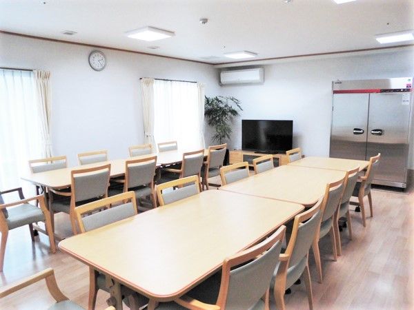 食堂にはテレビやエアコンが置かれ、長いテーブルが設置されている。