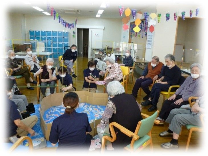 介護車両に移動する車椅子に乗った高齢女性と介助をする女性ヘルパー