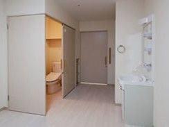 洗面所が付いたフローリングの部屋にはワイドタイプのスライド式のドアが設置されたトイレがある。