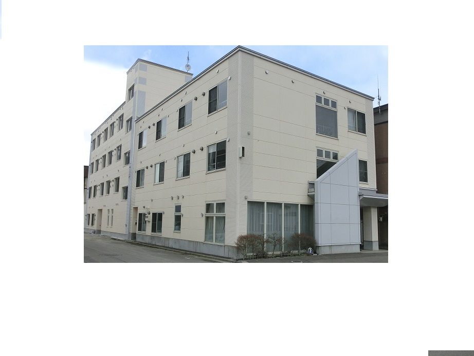 白い外壁の4階建て建築物