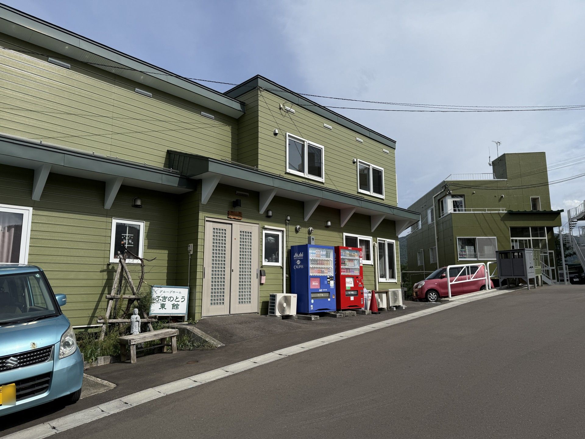 緑の建物と駐車場