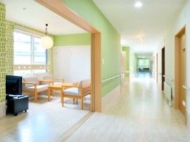 左手前にはテレビや応接セットが置かれたラウンジがあり、右にはまっすぐ伸びた廊下がある。