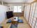 畳の部屋に木製の机と青い座布団が置かれている