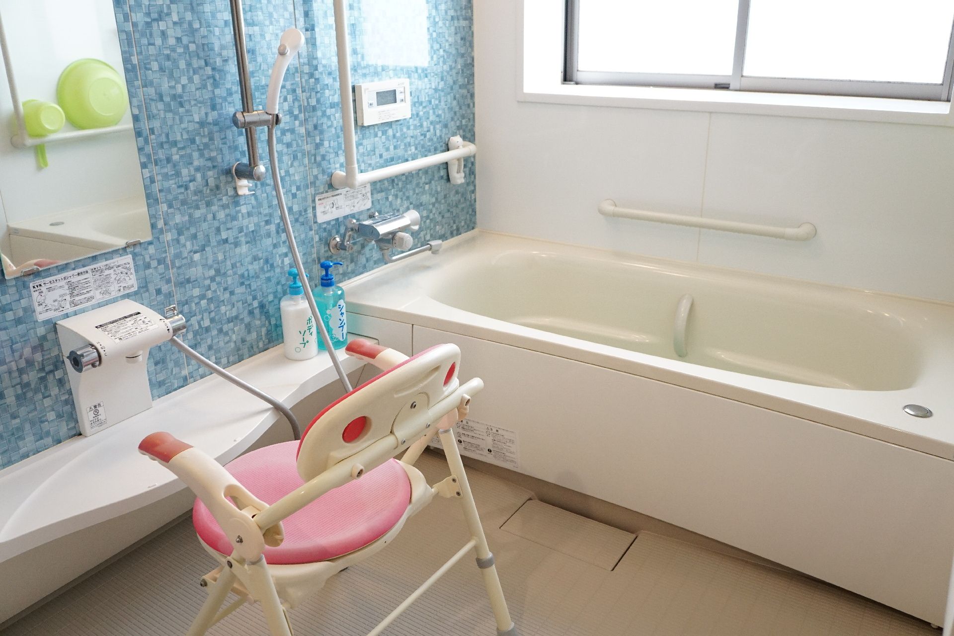 壁に手すりが設置され、滑りにくい床材が使われている浴室