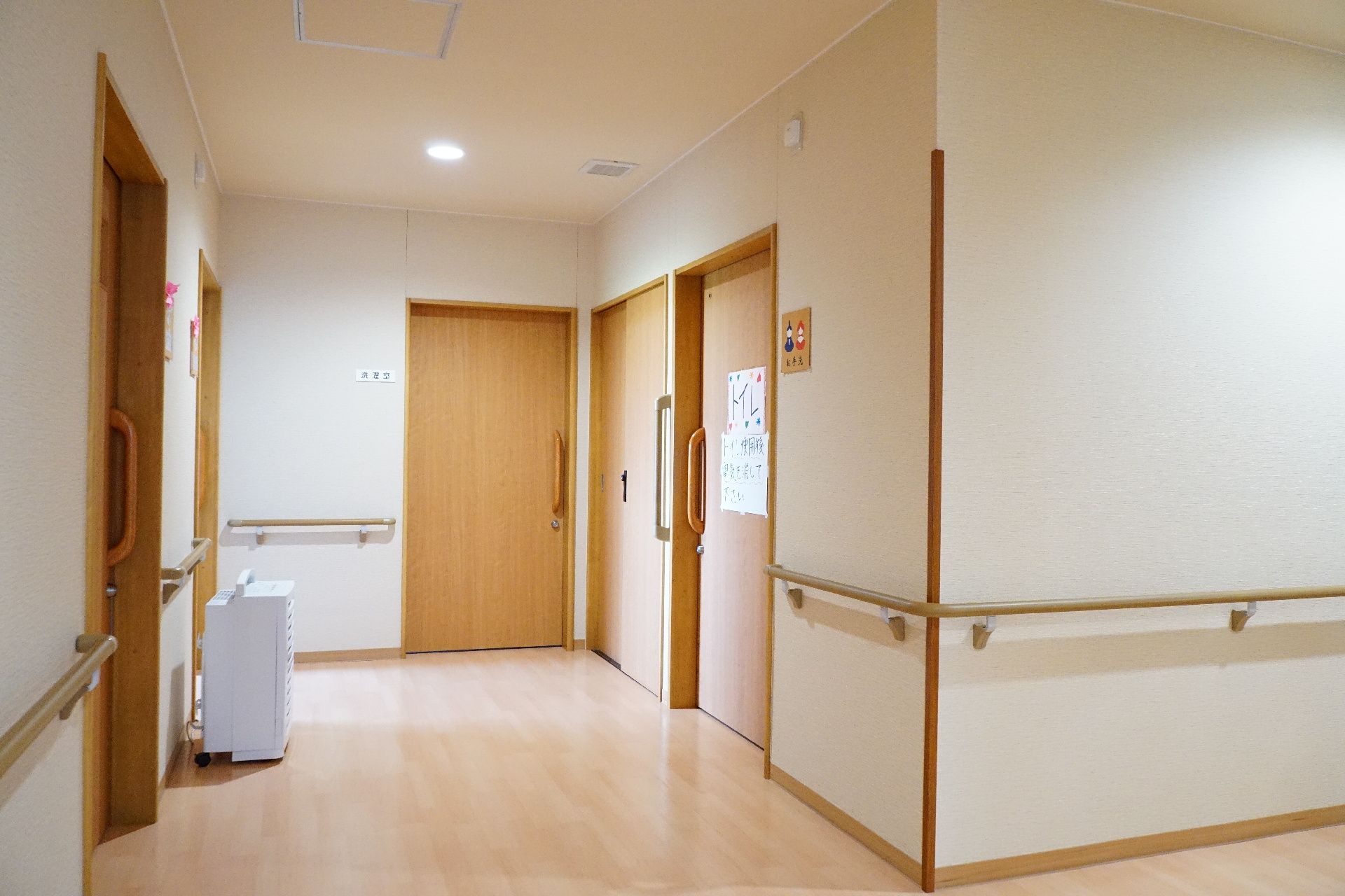 バリアフリー化され、段差が一切なく、壁に手すりが設置されている廊下