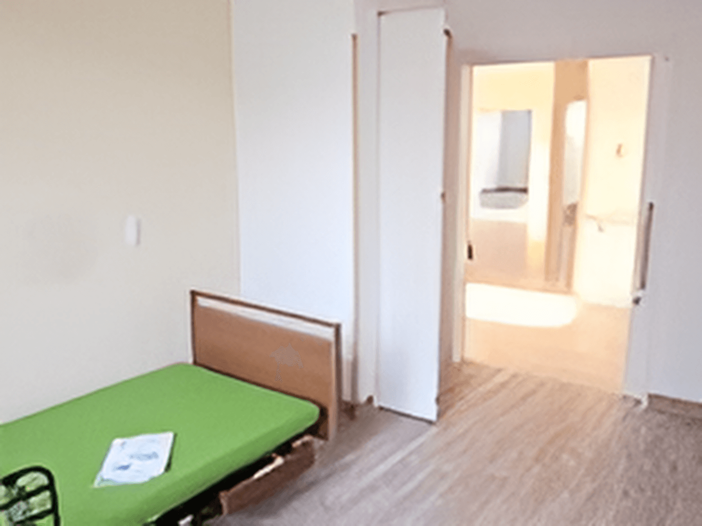 ベッドが設置された居室はフローリングで白い壁で扉は引き戸を採用している。