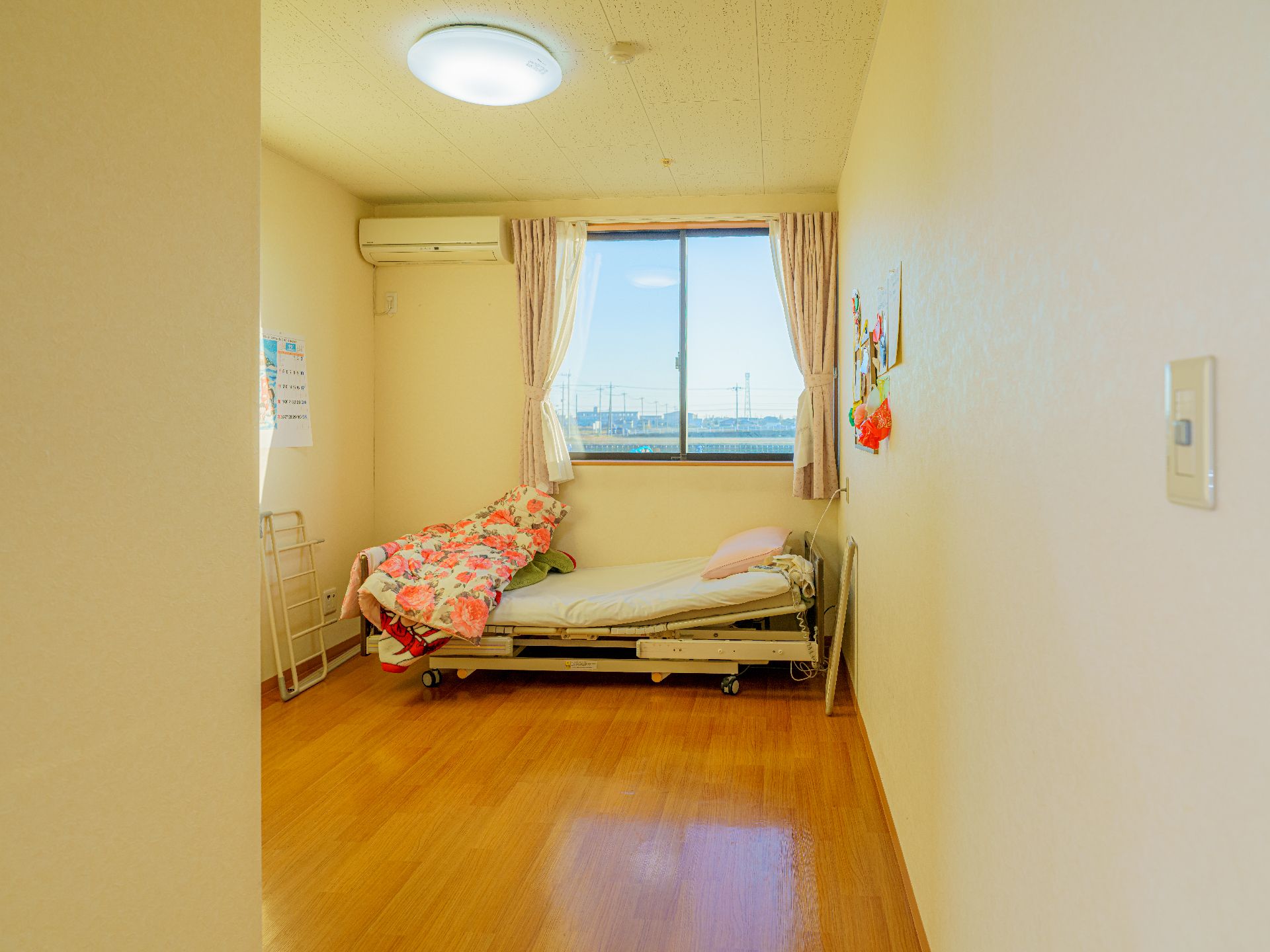 からだを動かしている高齢女性と男性スタッフの様子。施設内で体操しているときの一場面