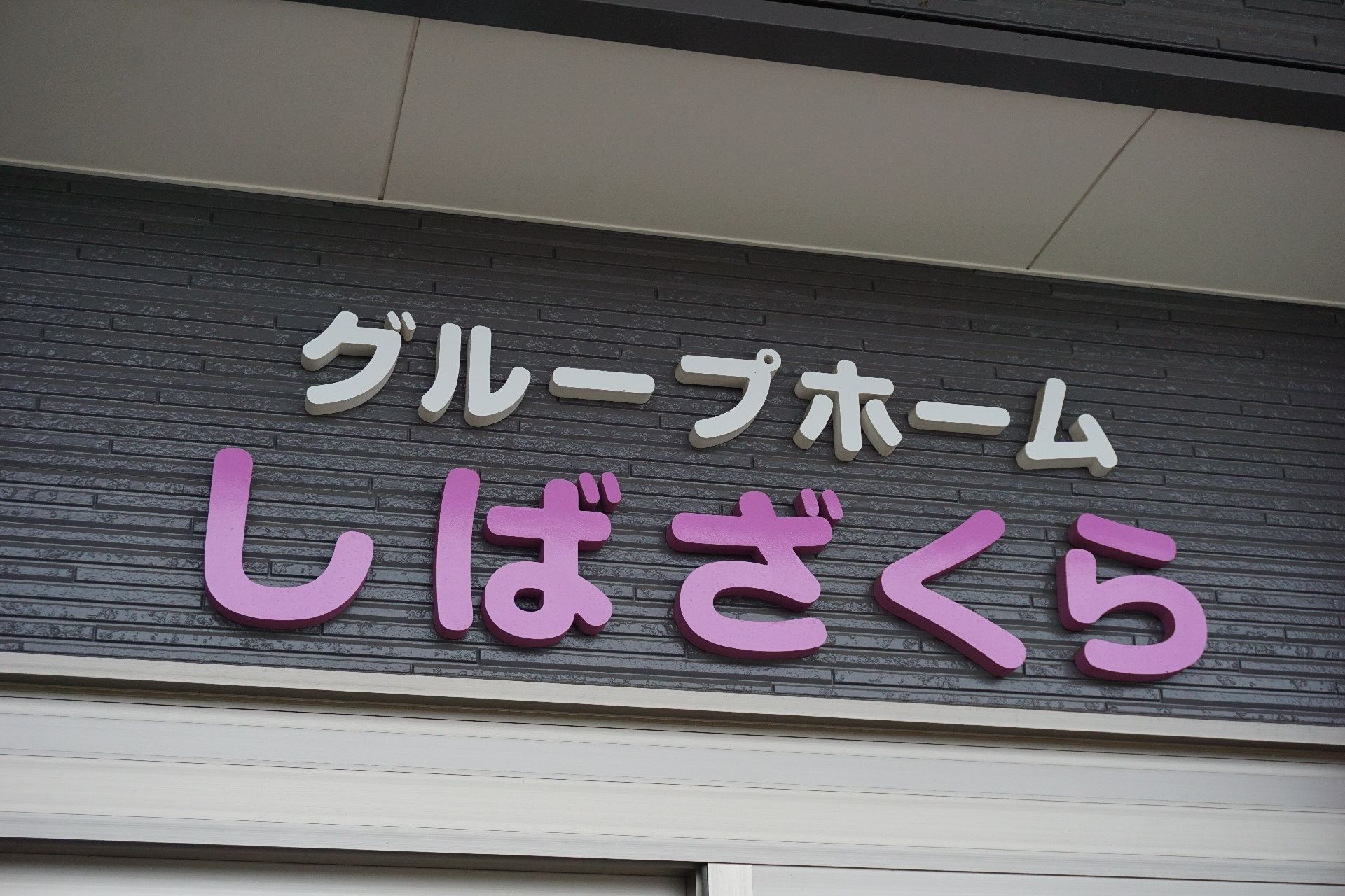 玄関ドアの上に設置されている、施設の名称が表記されている文字のプレート