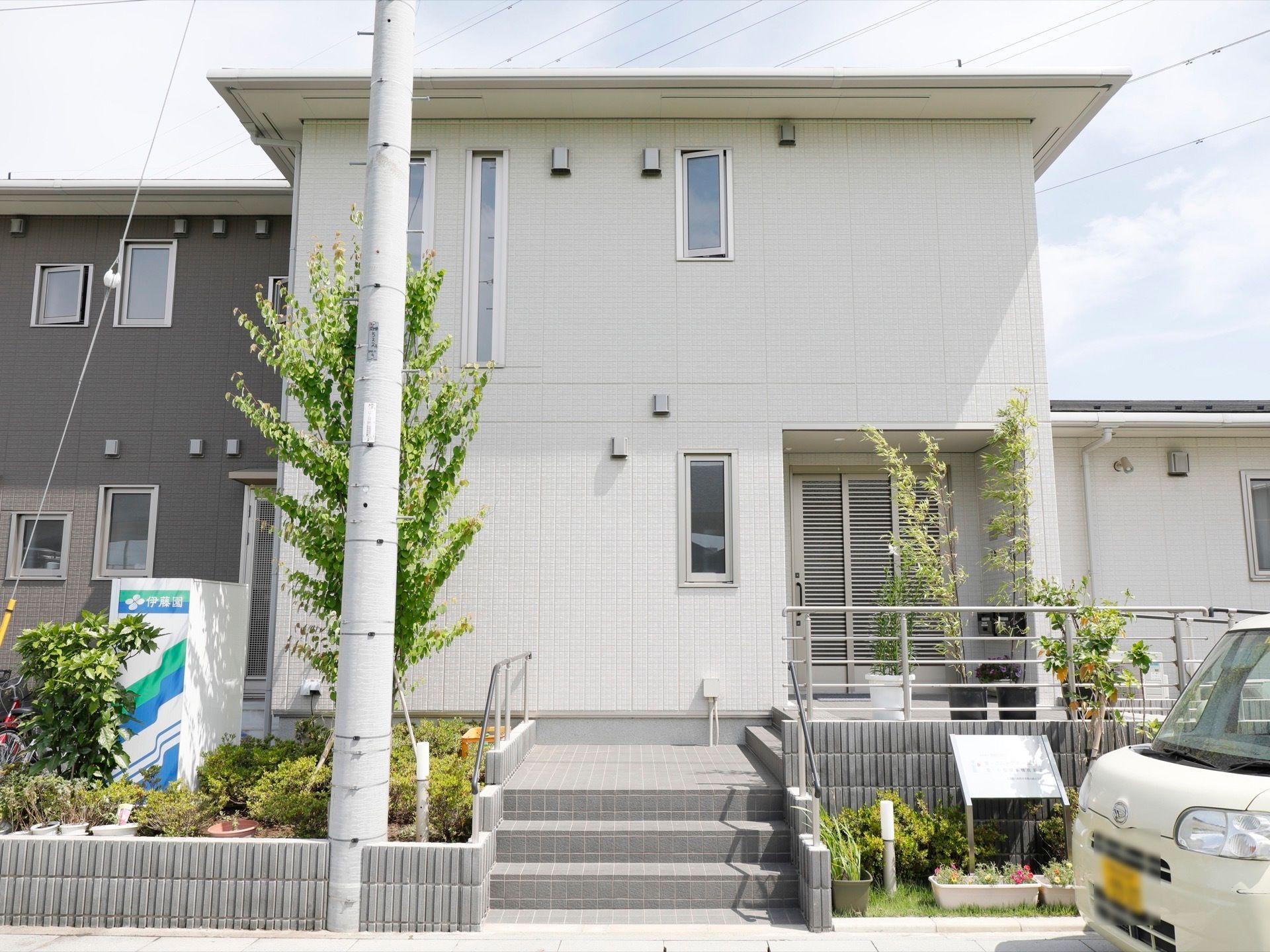 階段の両サイドに植え込みや花壇を完備している施設外観