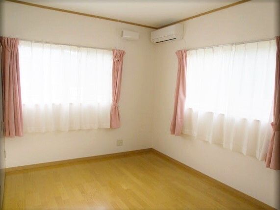 ２ヶ所に窓を設け、それぞれカーテンが掛けられている入居前の居室